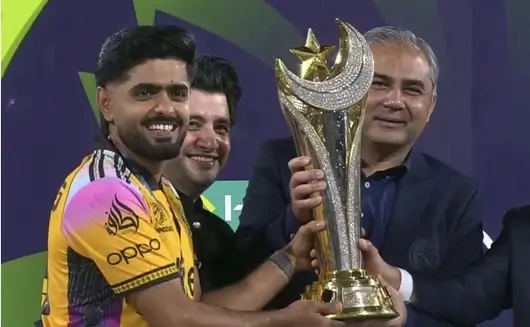Peshawar Zalmi players celebrate with captain Babar Azam lifting the PSL 11 championship trophy at a packed Gaddafi Stadium in Lahore